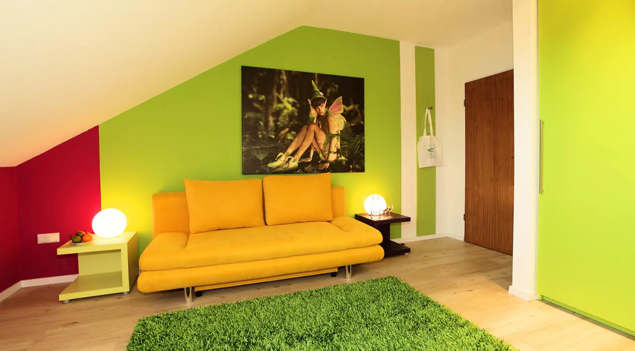 Hotel Wulff in Bad Sassendorf – Helles Hotelzimmer mit gelbem Sofa und grünen Wänden | Wellnesshotel Sauerland