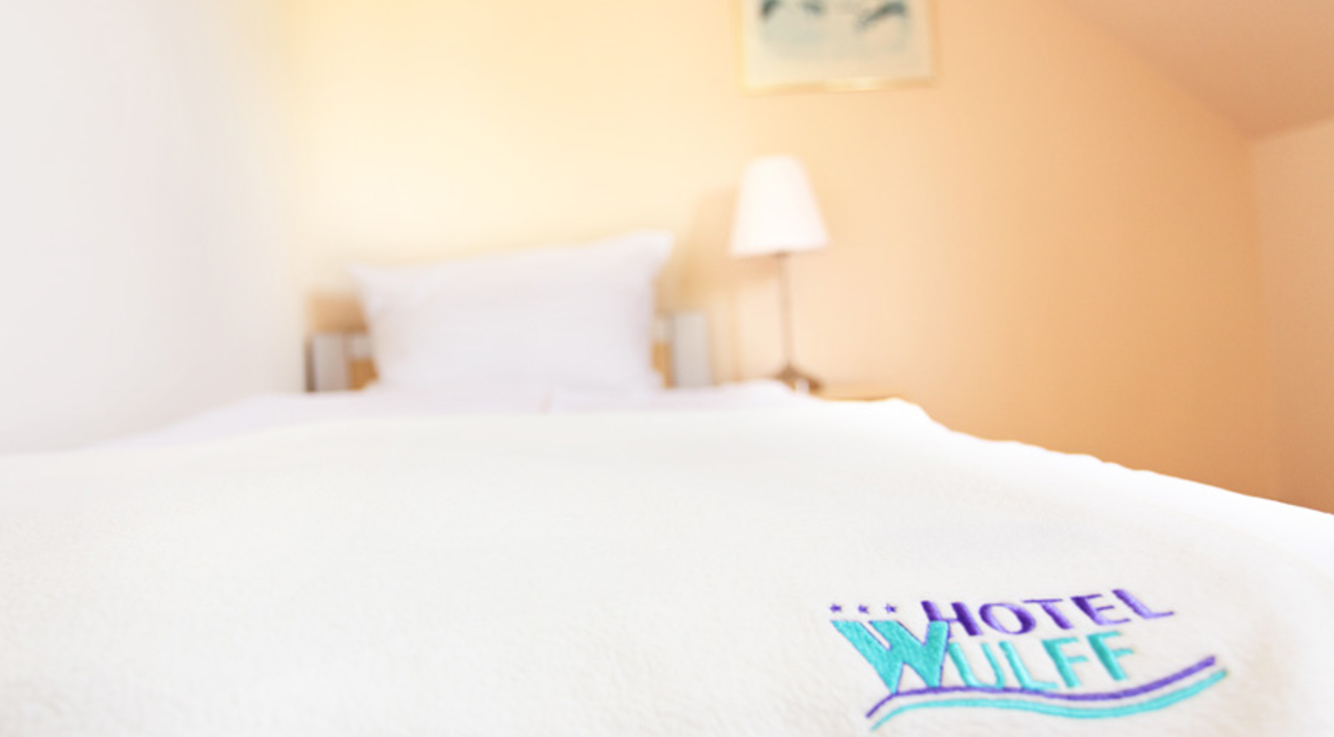 Hotel Wulff in Bad Sassendorf – Detailaufnahme des Hotelbetts mit Logo | Wellnesshotel Sauerland