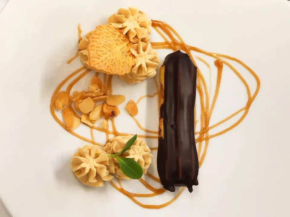 Exquisites Dessert mit Schokoladen-Eclair, Gebäck und Mandelsplittern, kunstvoll angerichtet im Villa Seilern Vital Resort.