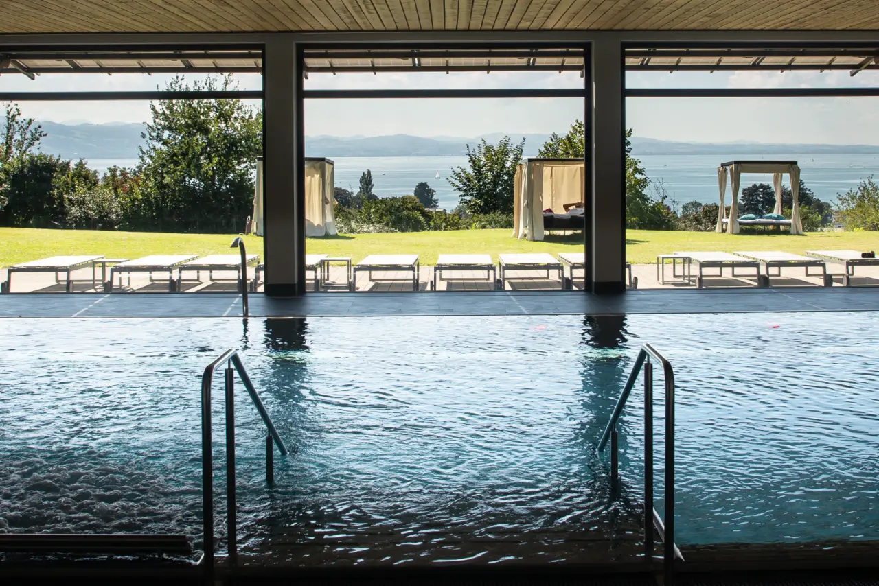 Innenpool mit Panoramablick auf den Bodensee und Liegewiese im Bodensee-Hotel Sonnenhof. Entspannung pur.