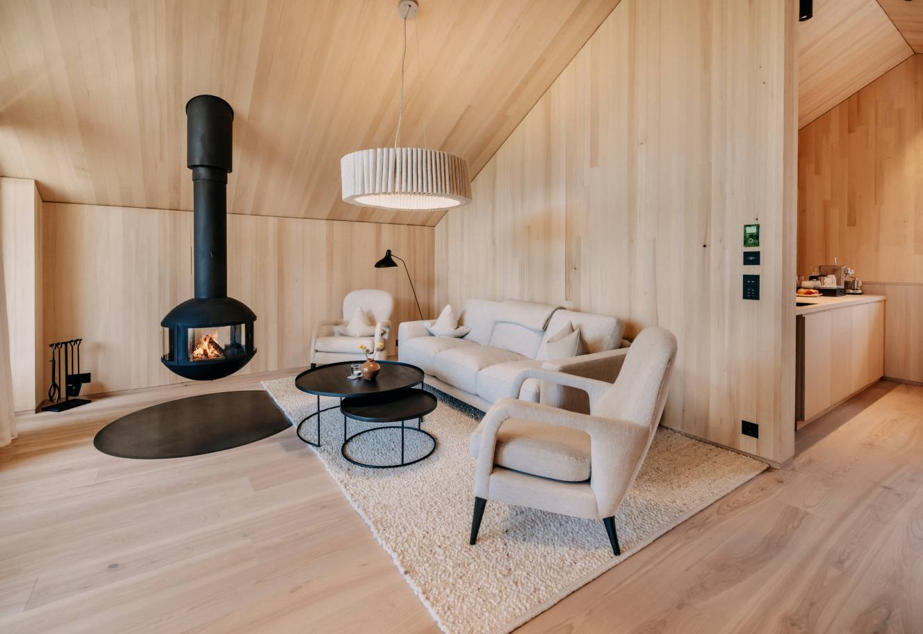 Naturhotel Forsthofgut in Leogang – Gemütliches Wohnzimmer einer Suite mit Kamin | Wellnesshotel Salzburger Land