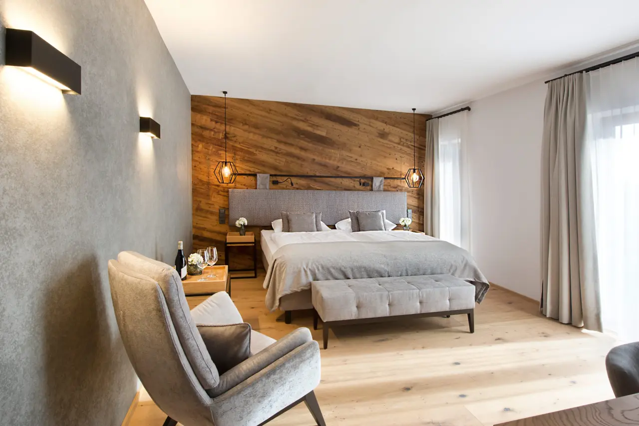 Modernes Doppelzimmer im Hotel Edelweiss mit Holzwand, bequemen Betten und stilvoller Einrichtung für entspannte Nächte.