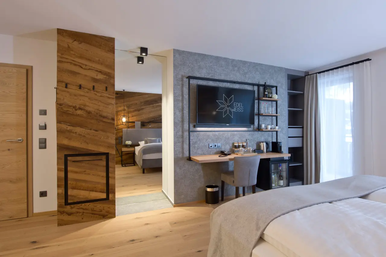 Modernes Doppelzimmer mit Holzelementen, Schreibtisch und TV im Hotel Edelweiss.
