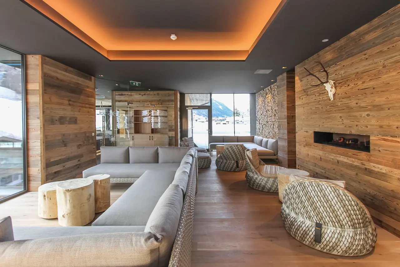 Gemütliche Spa-Lounge mit Kamin, Holzelementen und Bergblick im Hotel Edelweiss