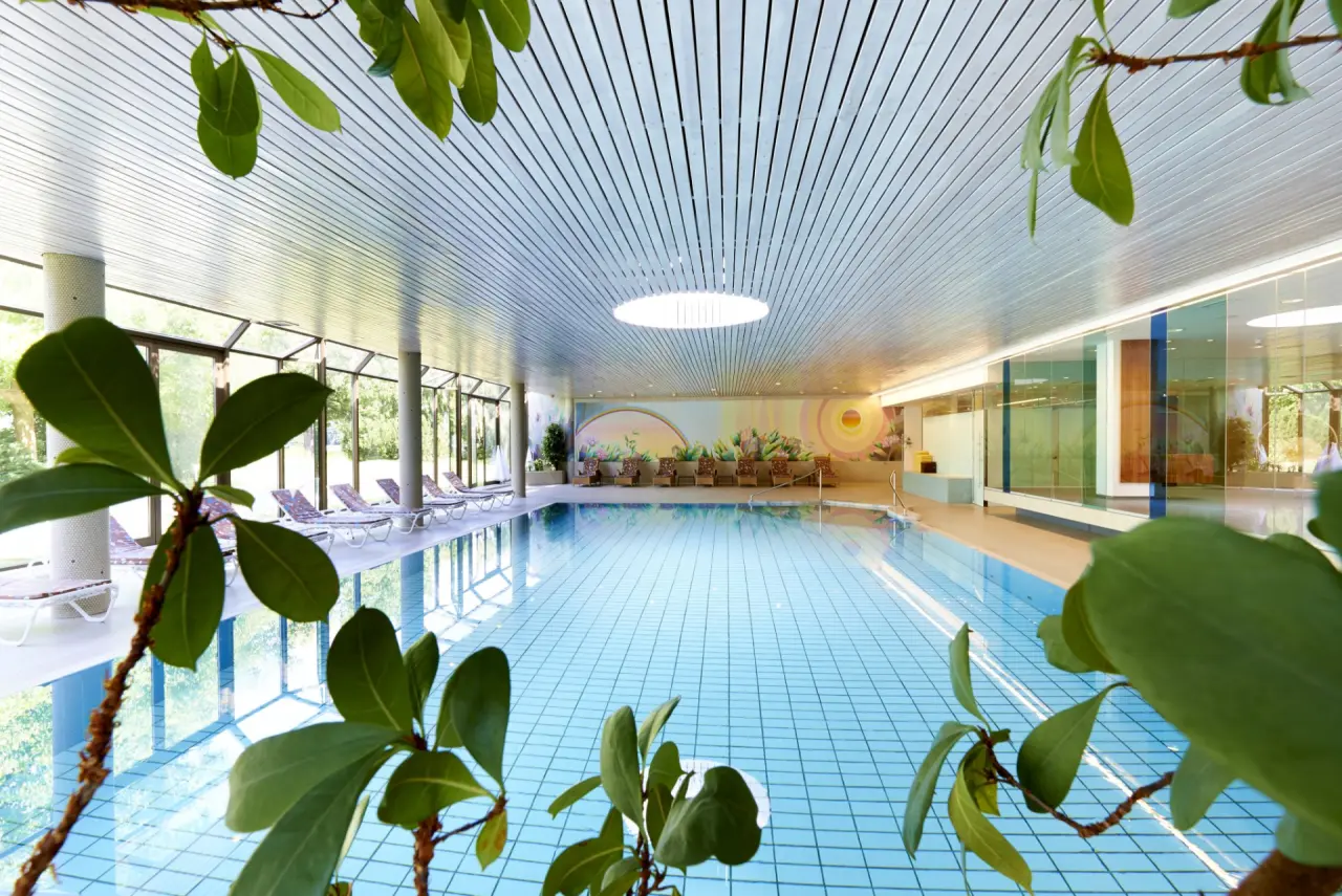 Grosszügiger Innenpool im Parkhotel Pörtschach mit Tageslicht, bequemen Liegen und entspannender Atmosphäre.