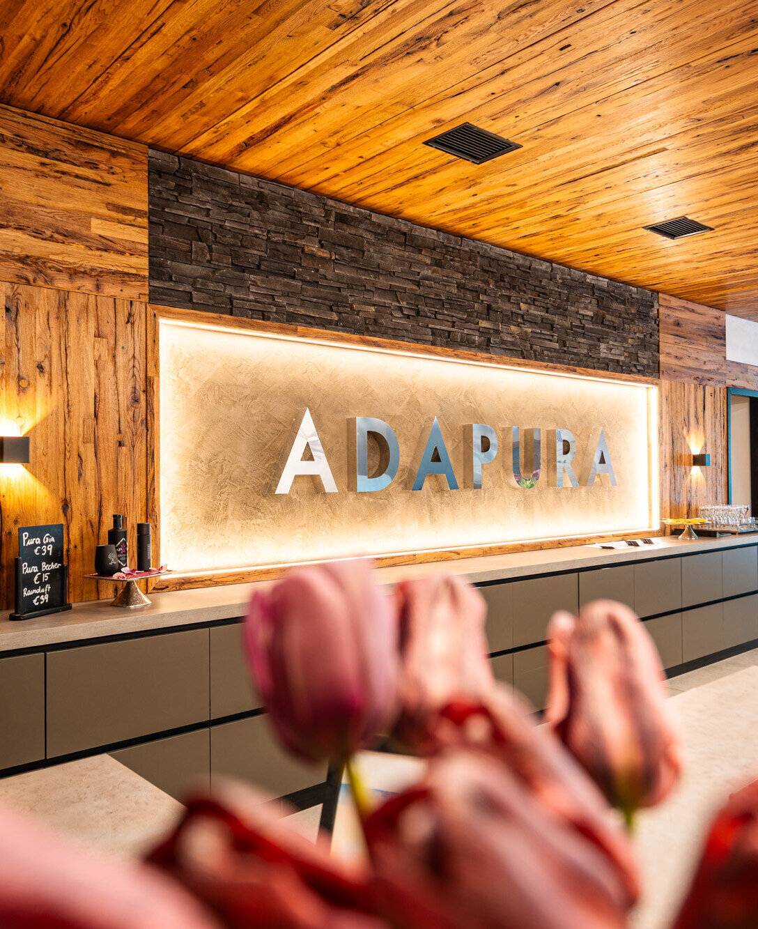 Hotel Adapura Wagrain in Wagrain – Beleuchtetes Hotellogo im Empfangsbereich | Wellnesshotel Salzburger Land