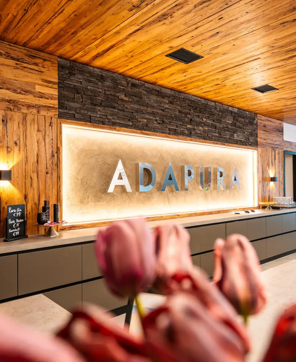 Hotel Adapura Wagrain in Wagrain – Beleuchtetes Hotellogo im Empfangsbereich | Wellnesshotel Salzburger Land