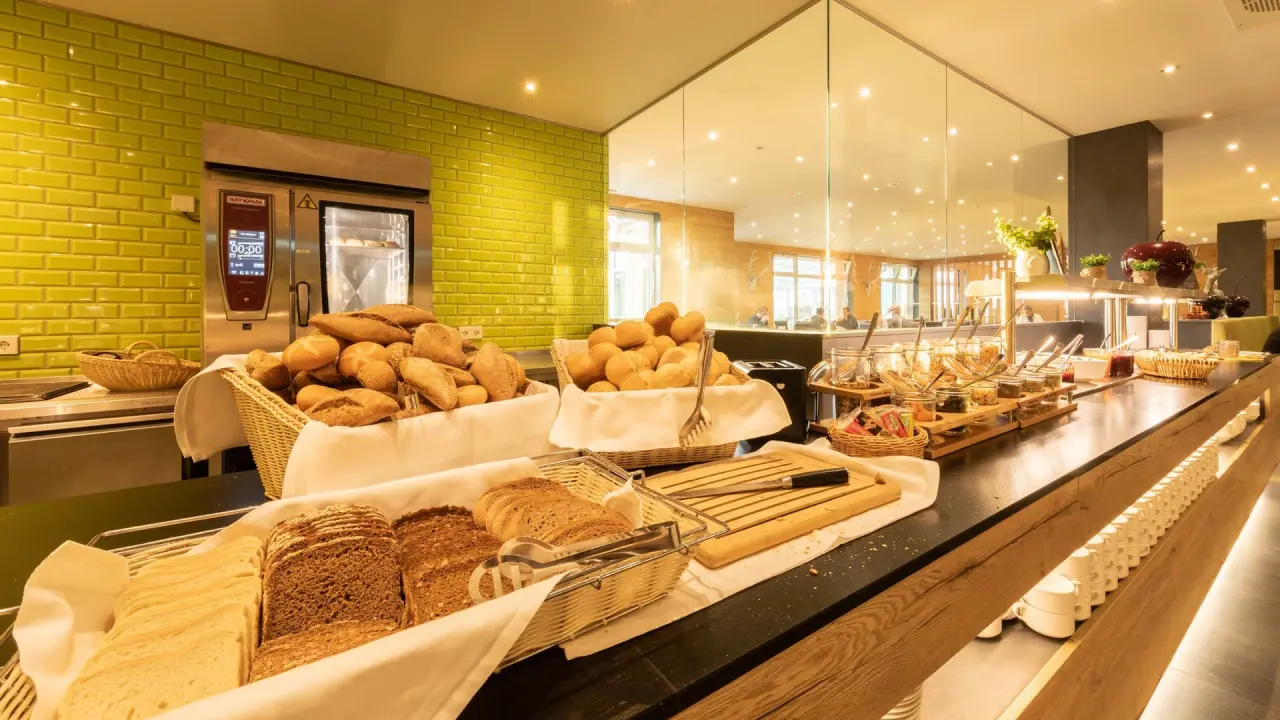 Reichhaltiges Frühstücksbuffet mit frischen Backwaren und Müsli-Station im Restaurant des Fair Hotel.