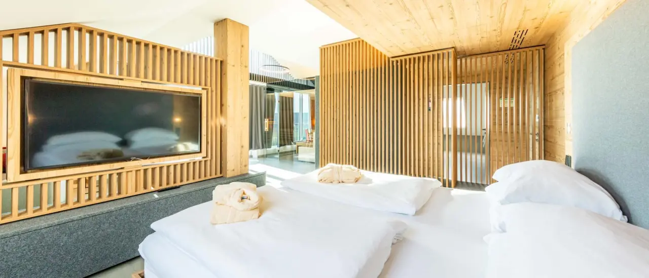 Modernes Hotelzimmer im Fair Hotel mit Holzelementen, großem Bett und Flachbildfernseher für einen entspannten Aufenthalt.