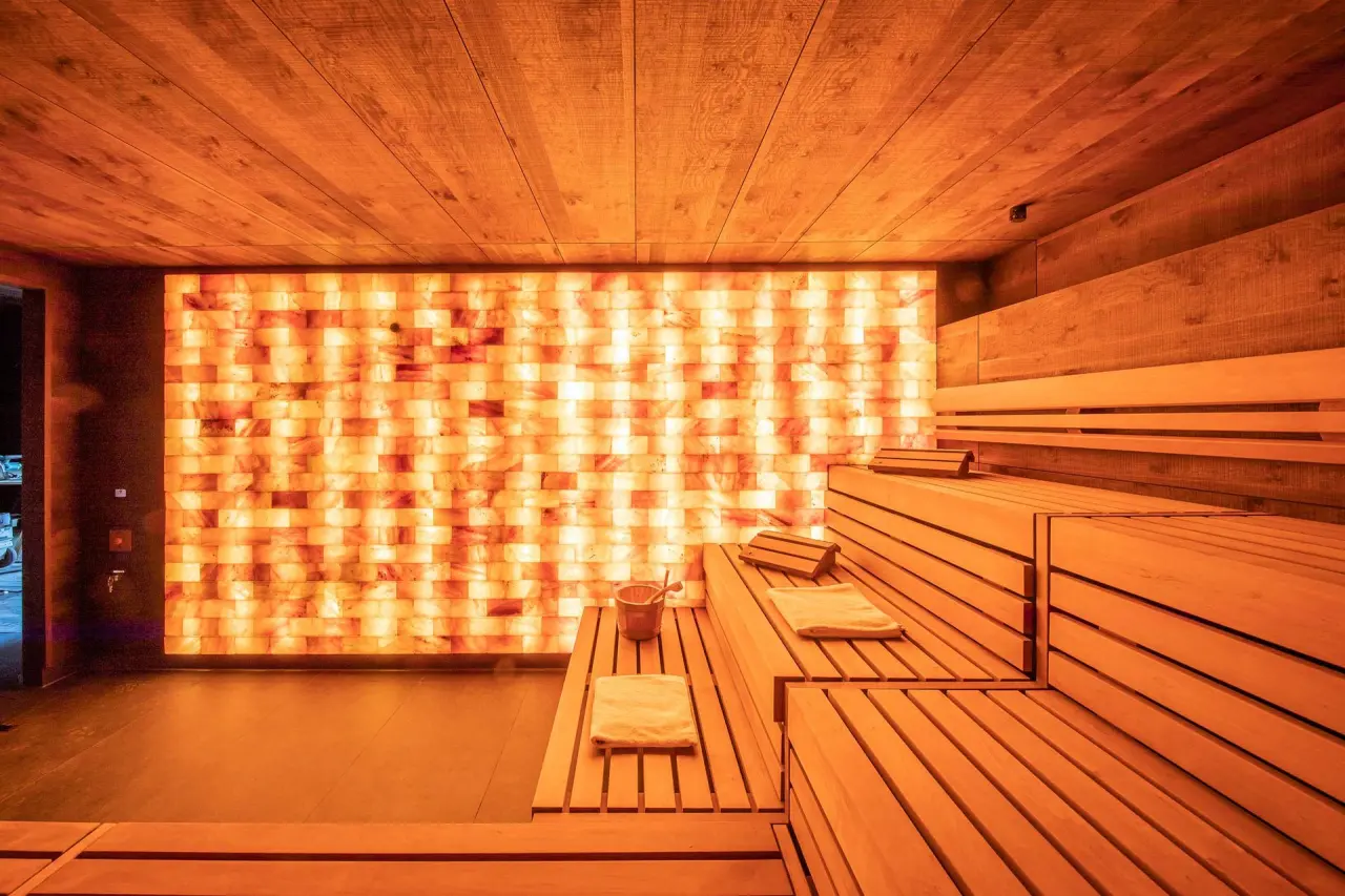 Moderne Salzstein-Sauna mit warmem Licht und Holzinterieur im Fair Hotel Spa-Bereich.