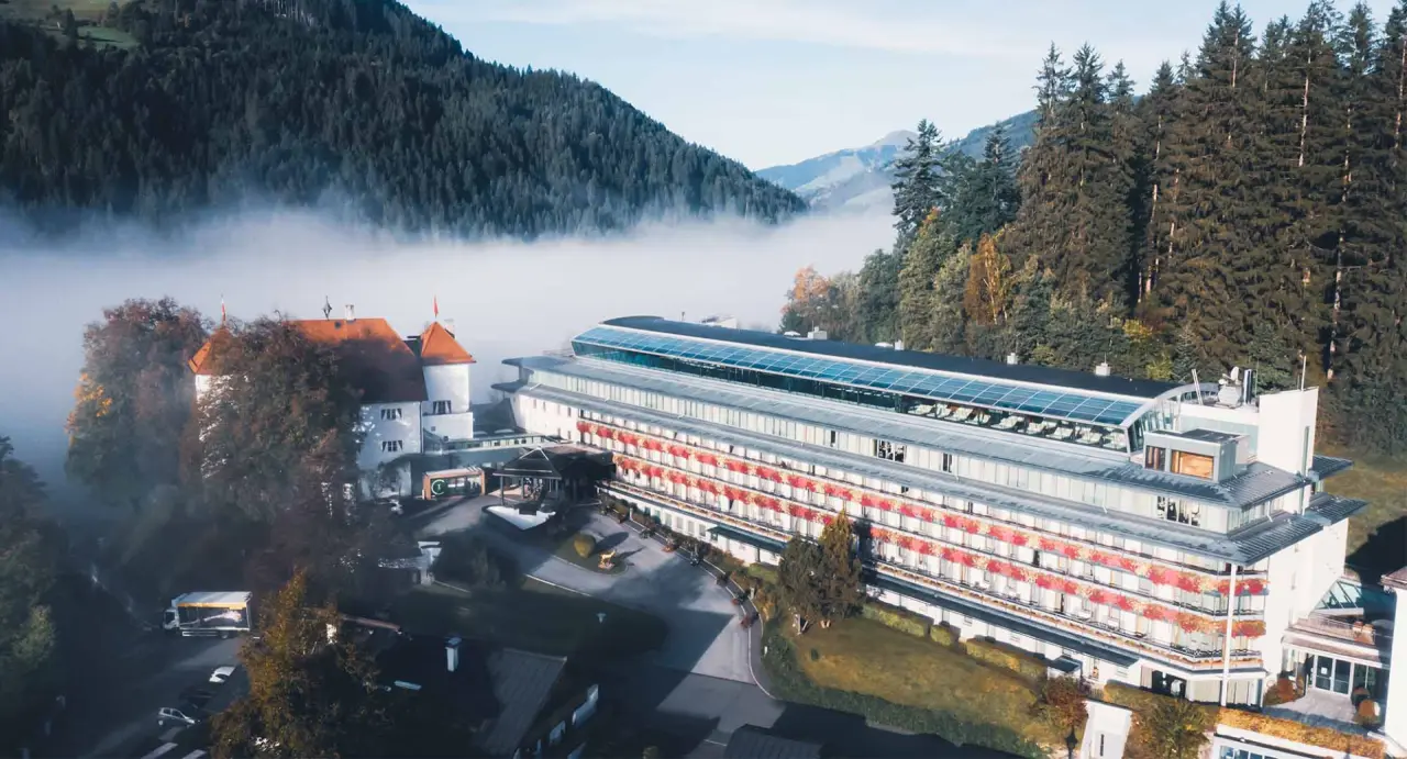 Levenberg Schlosshotel in Kitzbühel mit Alpenpanorama und Nebelstimmung. Luxuriöses Wellnesshotel in den Bergen.