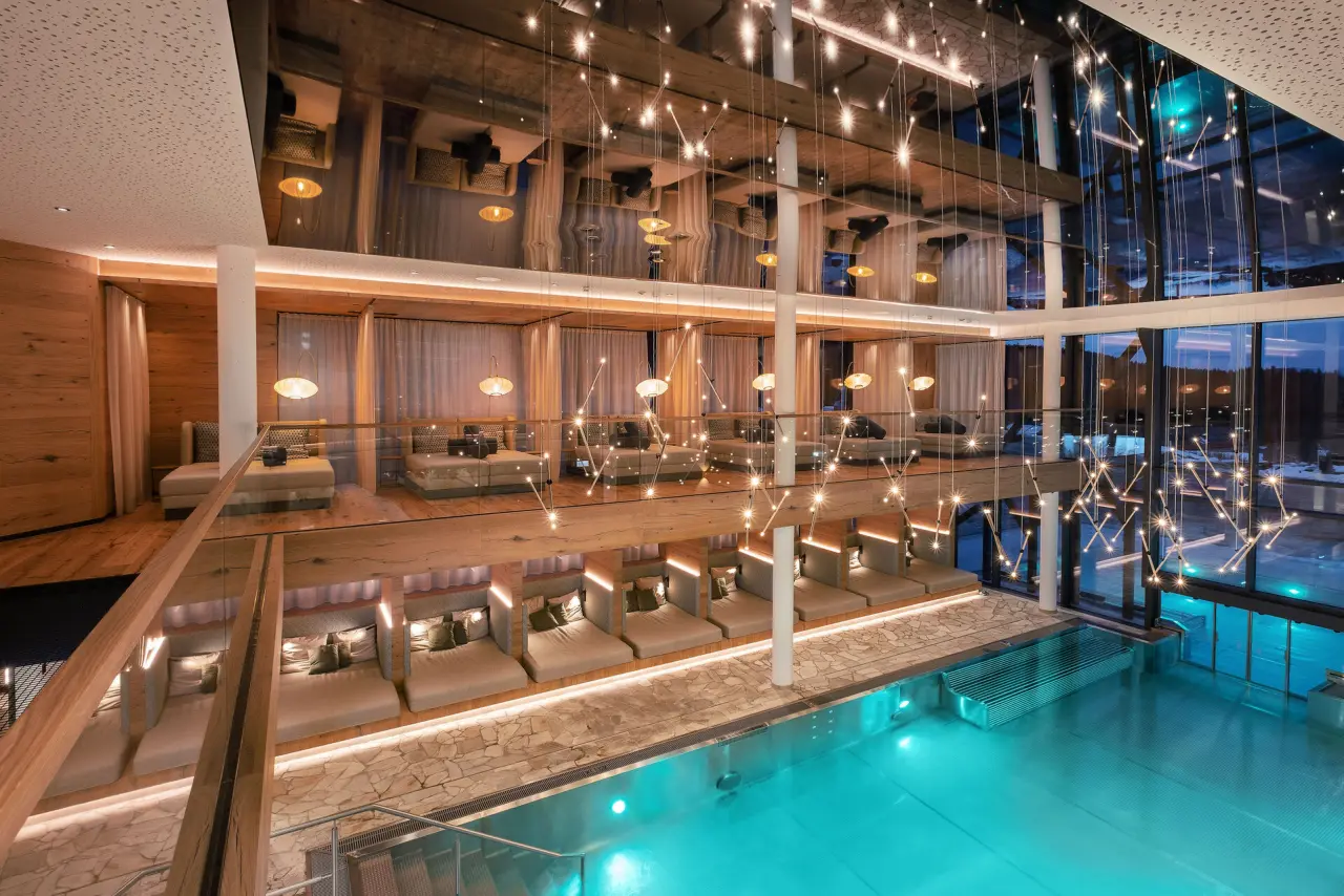 Luxuriöser Innenpool mit stilvollen Liegebereichen und moderner Beleuchtung im Wellness & Naturhotel Tonihof.