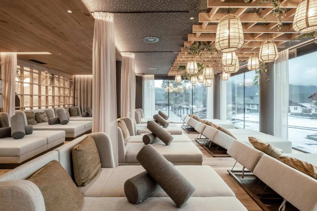 Entspannungsbereich mit bequemen Liegen und Blick auf die verschneite Natur im Wellness & Naturhotel Tonihof.