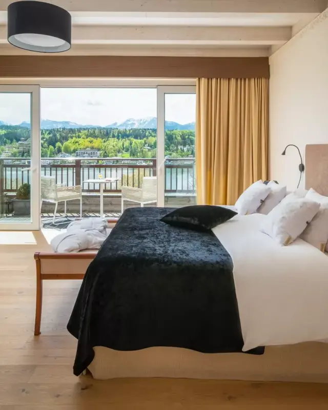 Komfortables Hotelzimmer im Seehotel Europa mit Balkon und Panoramablick auf den See und die umliegenden Berge.
