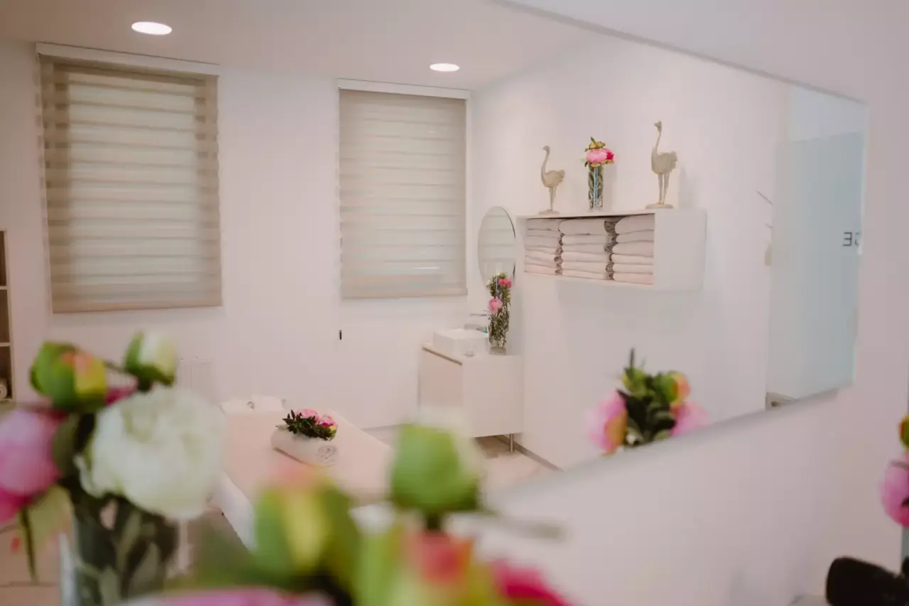 Heller Behandlungsraum im Spa-Bereich des Seehotel Europa mit Massageliege, frischen Handtüchern und Blumen.