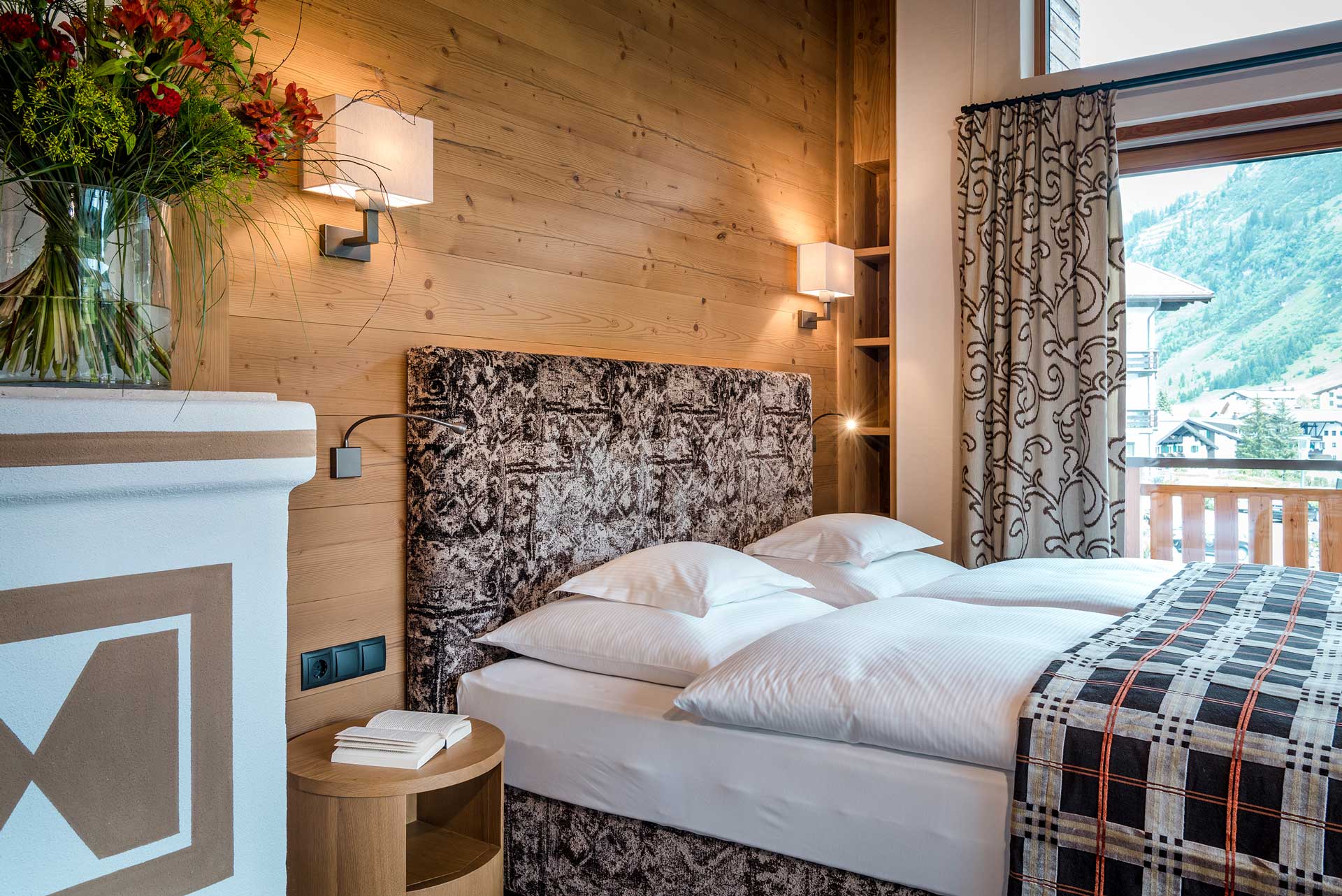 Hotel Auenhof in Lech am Arlberg – Modernes Doppelzimmer mit Holzwand und Bergblick | Wellnesshotel Arlberg