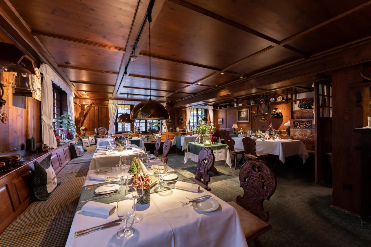 Traditionelles Restaurant im Hotel Ochsen Schönwald mit festlich gedeckten Tischen und gemütlichem Holzinterieur.