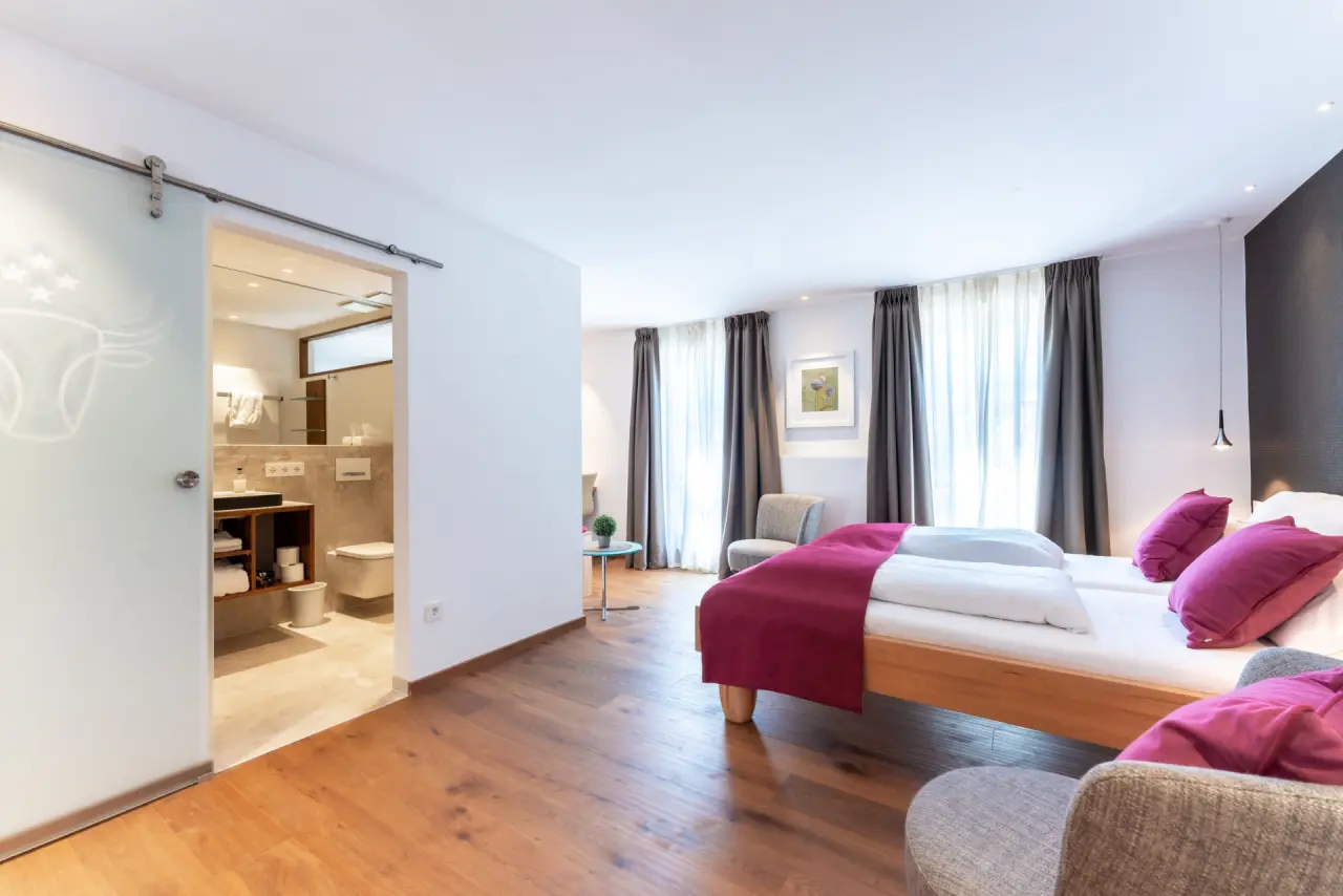Modernes Doppelzimmer mit Holzboden und offenem Bad im Hotel Ochsen Schönwald