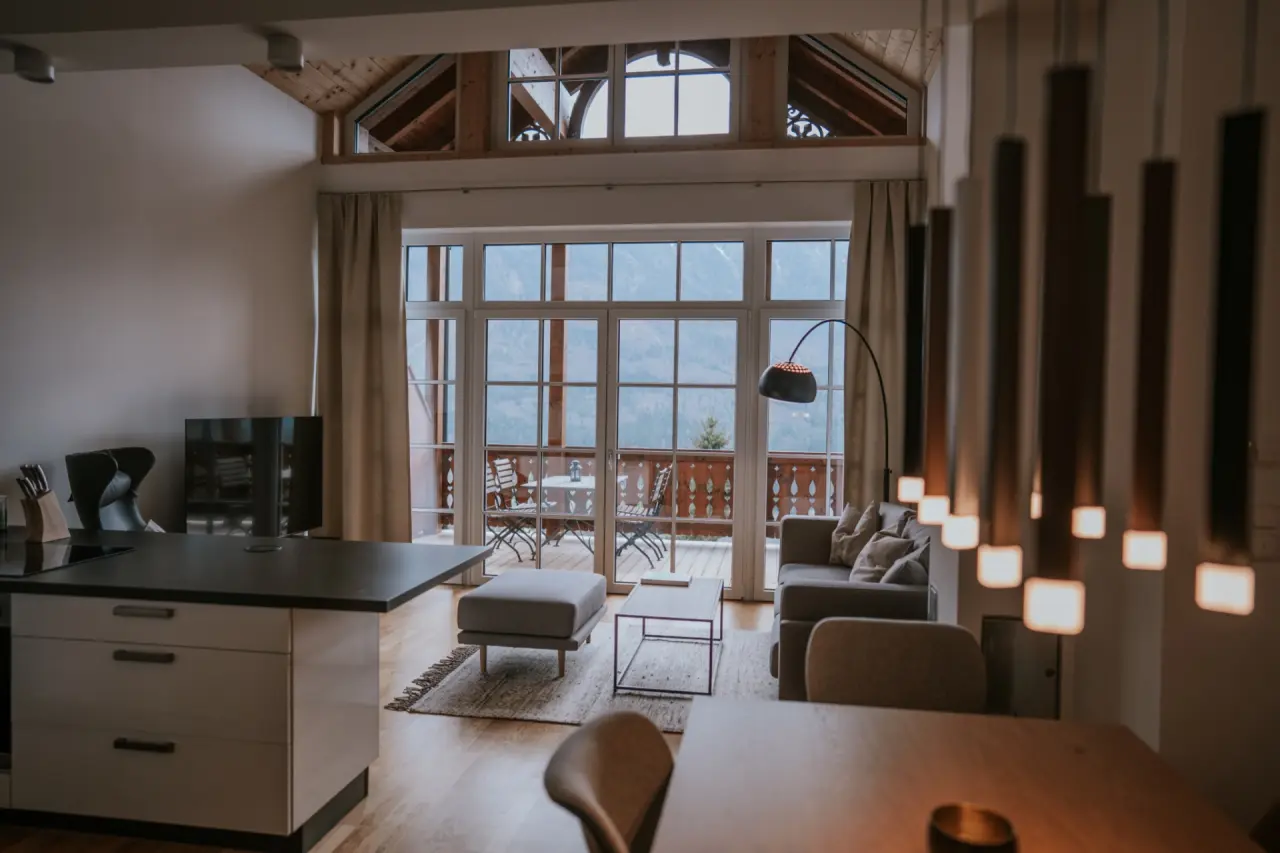 Gemütliche Suite im Hotel DIE WASNERIN mit Wohnbereich, offener Küche und Balkon mit Alpenpanorama.