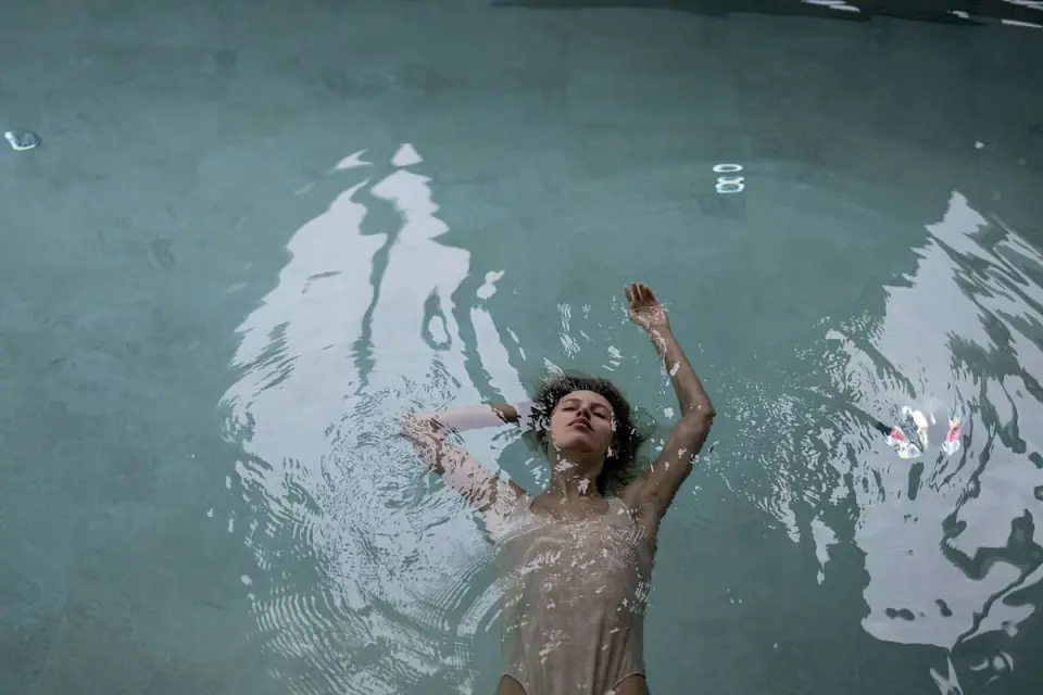 Entspannte Frau schwebt im Pool des Hotel Goldene Rose. Wellness und Erholung im Spa-Bereich.