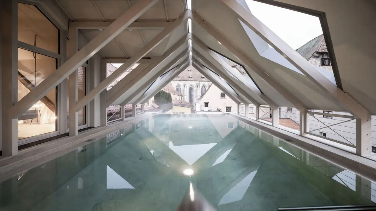 Einzigartiger Rooftop-Pool mit Glasdach und Blick auf die historische Altstadt im Hotel Goldene Rose.