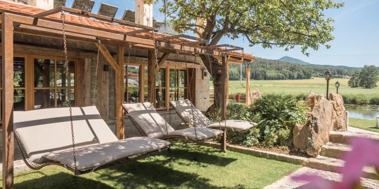 Entspannende Hängesessel im Gartenbereich des Natur- & Wellnesshotel Brunner Hof ****S mit Blick auf die Natur.
