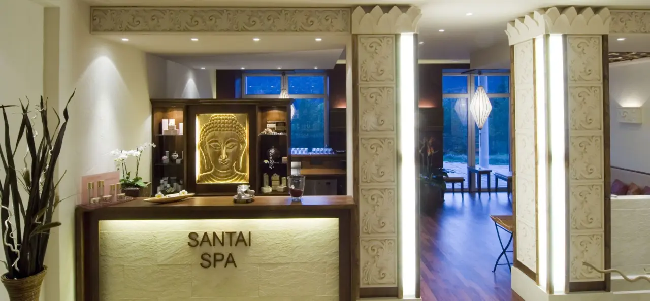 Empfangsbereich des Santai Spa im Reblinger Hof mit Buddha-Relief und entspannender Beleuchtung