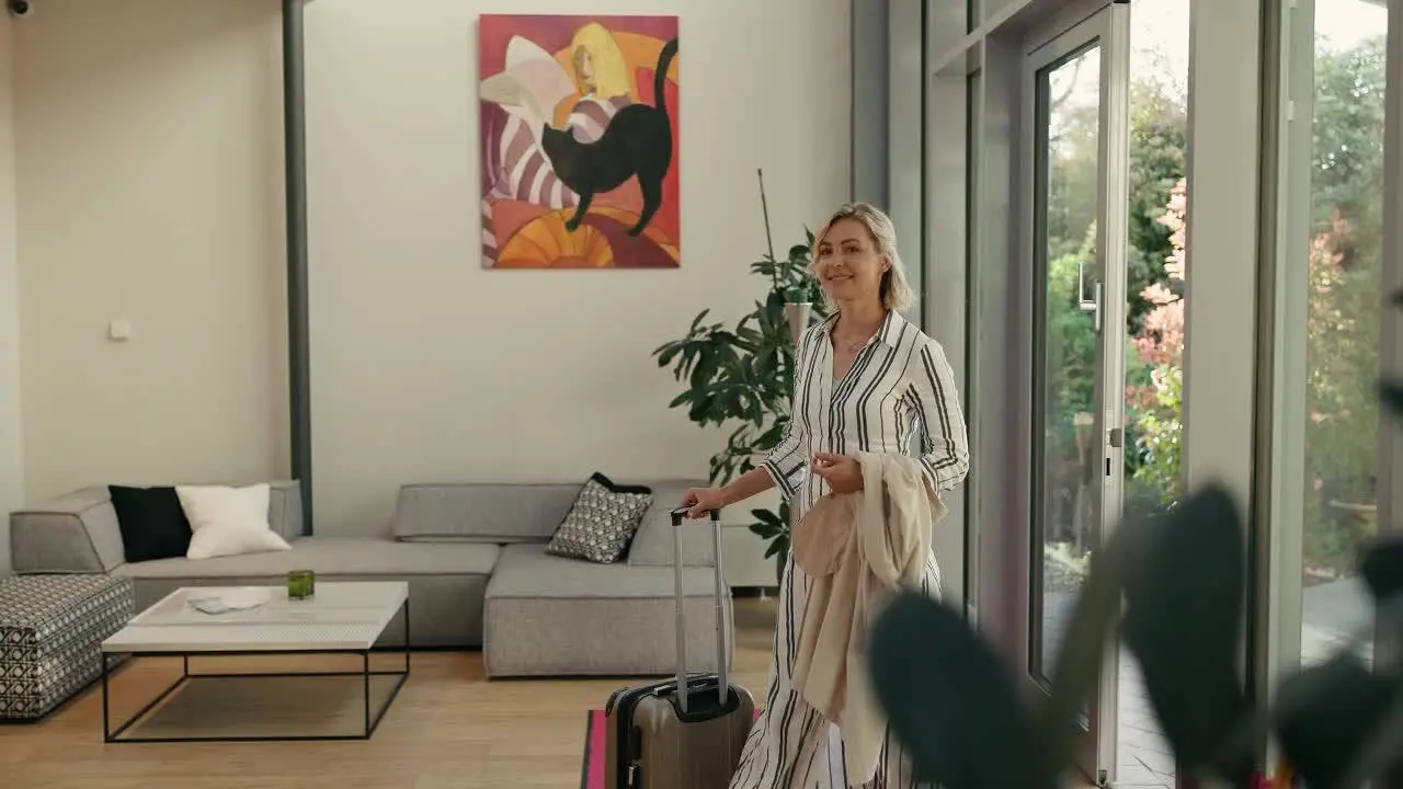 Frau mit Koffer im modernen Empfangsbereich des Hotel Calamus mit Sofa, Kunstwerk und Blick ins Grüne.