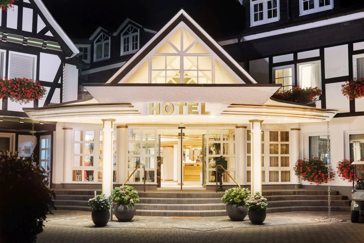 Beleuchteter Eingang des charmanten Romantik Hotel Haus Platte im Fachwerkstil bei Nacht.