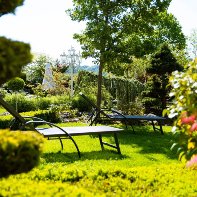 Gepflegter Hotelgarten mit Sonnenliegen und üppiger Vegetation im Ringhotel Teutoburger Wald