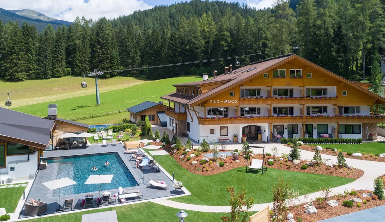 Bad Moos Dolomites Spa Resort in Sexten – Außenansicht mit Pool und Liegewiese | Wellnesshotel Südtirol