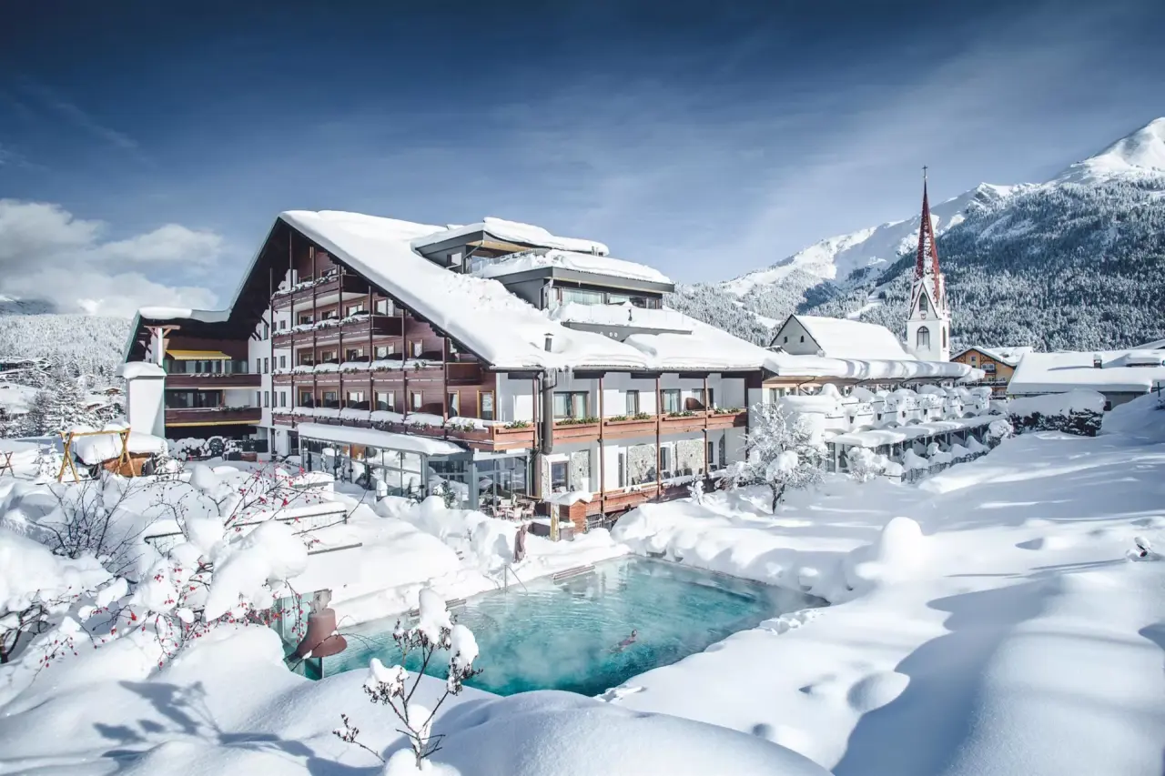 Winterliches Hotel Kosterbräu mit beheiztem Aussenpool und verschneiter Berglandschaft