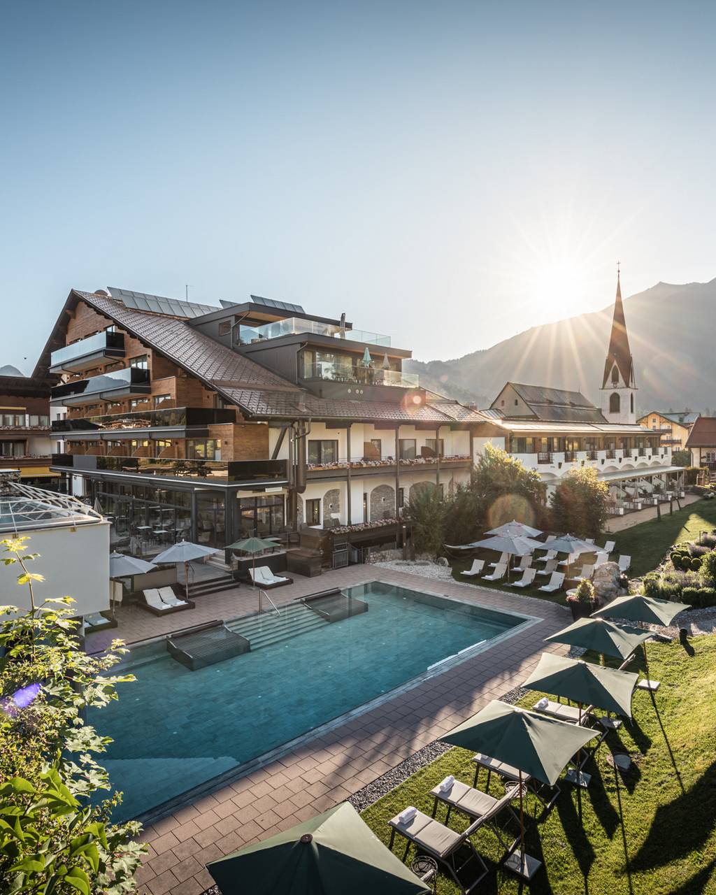 Hotel Kosterbräu in Seefeld – Hotelgebäude mit Außenpoolbereich und Liegewiese | Wellnesshotel Tirol