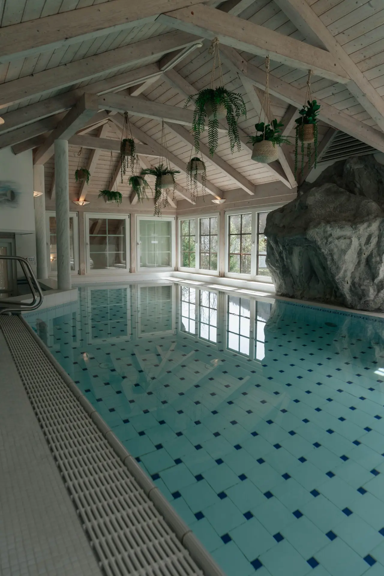 Grosszügiger Innenpool im Bergrose Hideaway mit Holzdach, grossen Fenstern und natürlicher Felswand für entspannte Stunden.