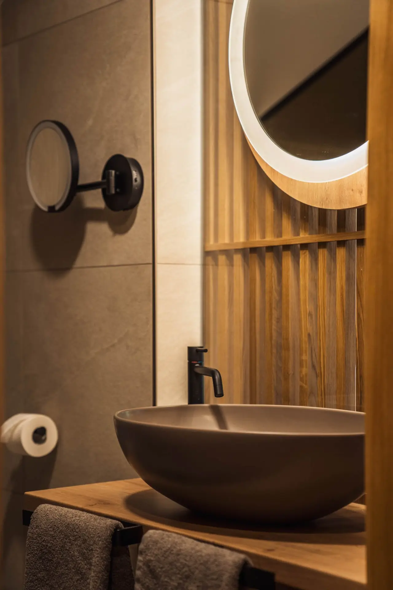 Modernes Badezimmer mit beleuchtetem Spiegel und stilvollem Waschbecken im Hotel Bergrose Hideaway.