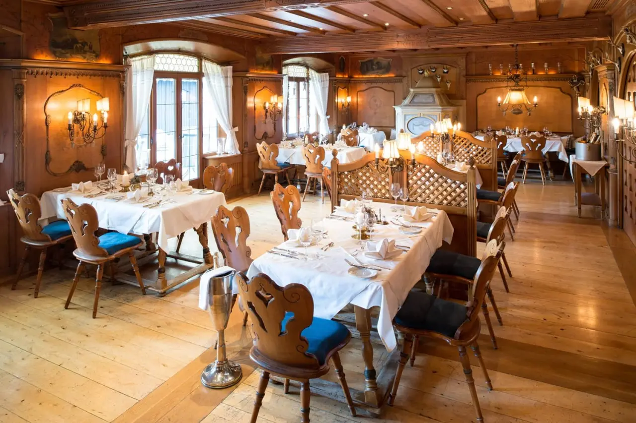 Traditionelles Restaurant im Parkhotel Wallgau mit holzgetäfelten Wänden, elegant gedeckten Tischen und gemütlicher Atmosphäre.