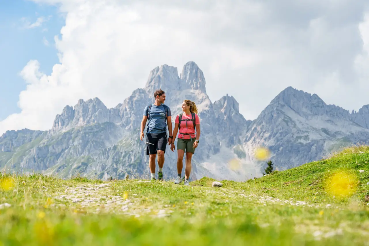 Wanderndes Paar genießt die Berglandschaft der Bischofsmütze. Aktiver Urlaub im Hotel Bischofsmütze.