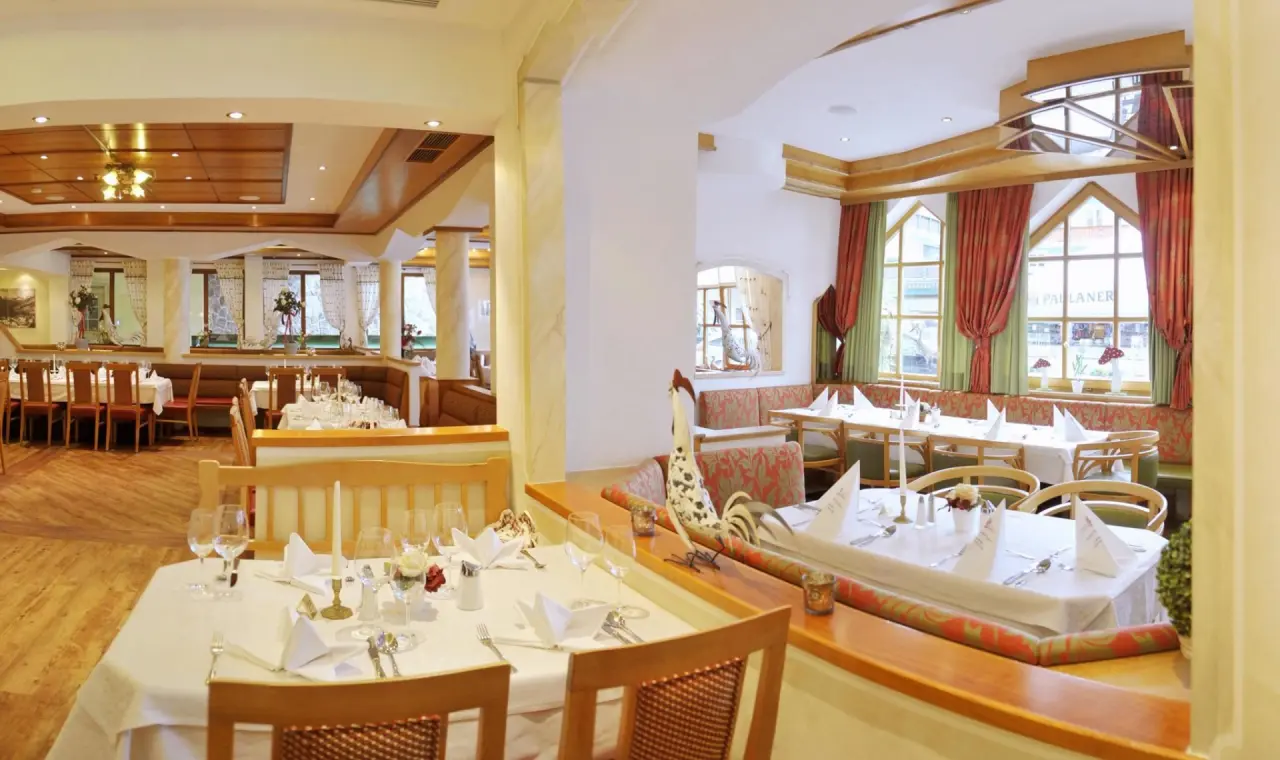 Gemütliches Restaurant mit traditionellem Dekor und festlich gedeckten Tischen im Hotel Bischofsmütze.