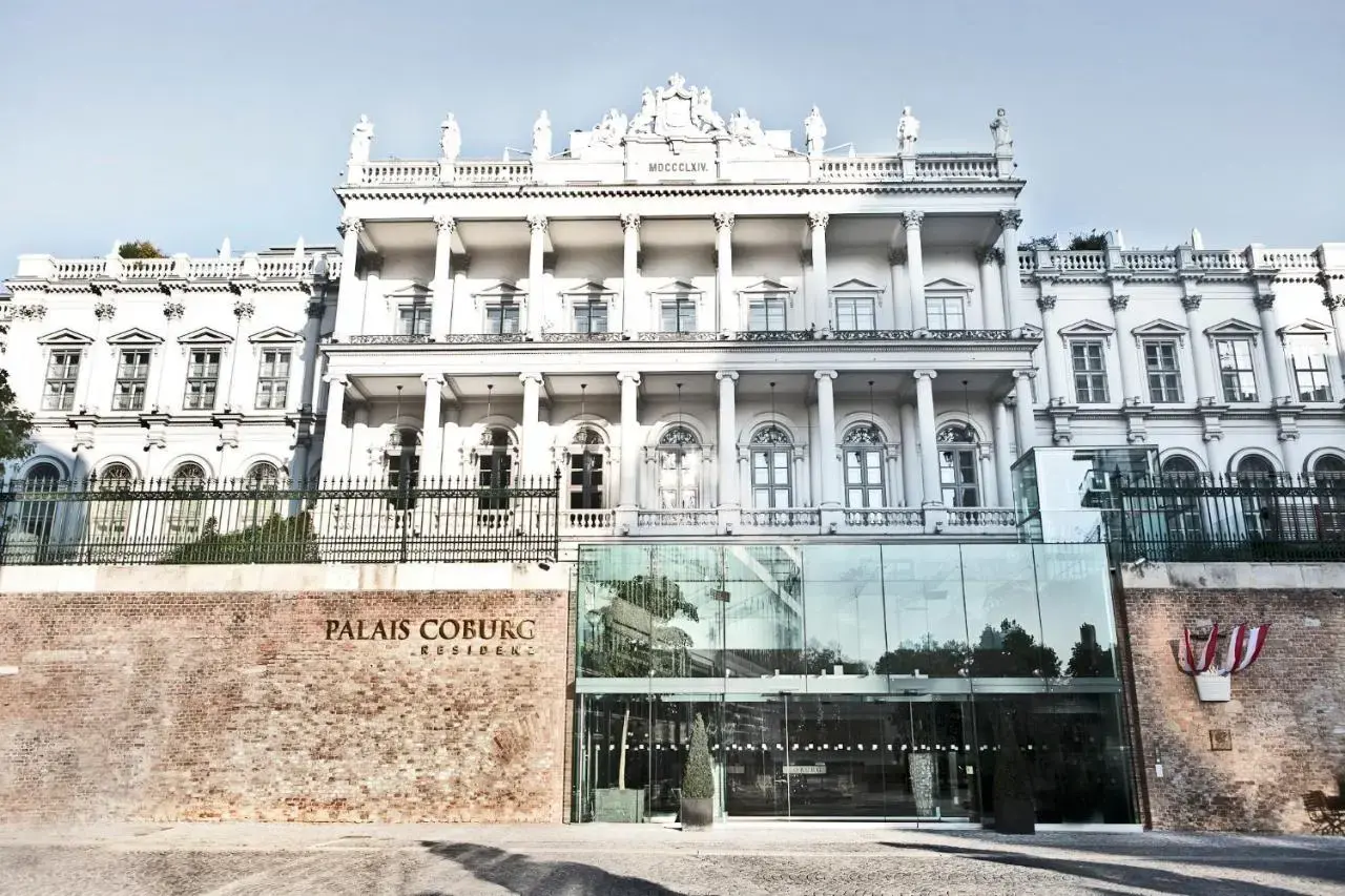 Aussenansicht des Palais Coburg Residenz in Wien: Historische Fassade und moderner Glas-Eingang.