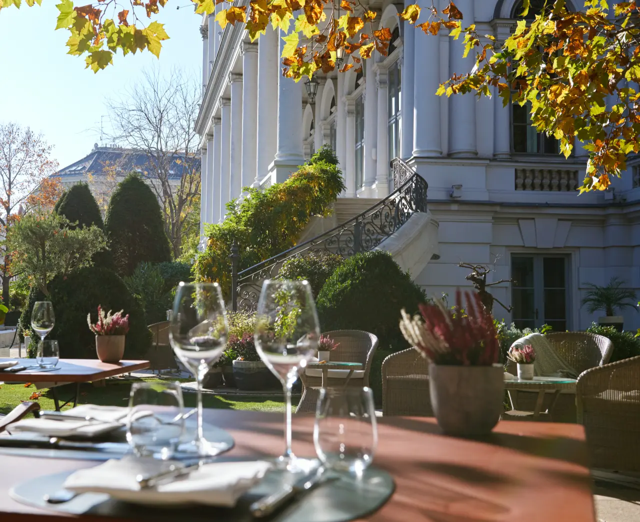 Eleganter Aussenbereich mit Restaurant-Tischen und historischer Fassade des Palais Coburg Residenz im Herbst.