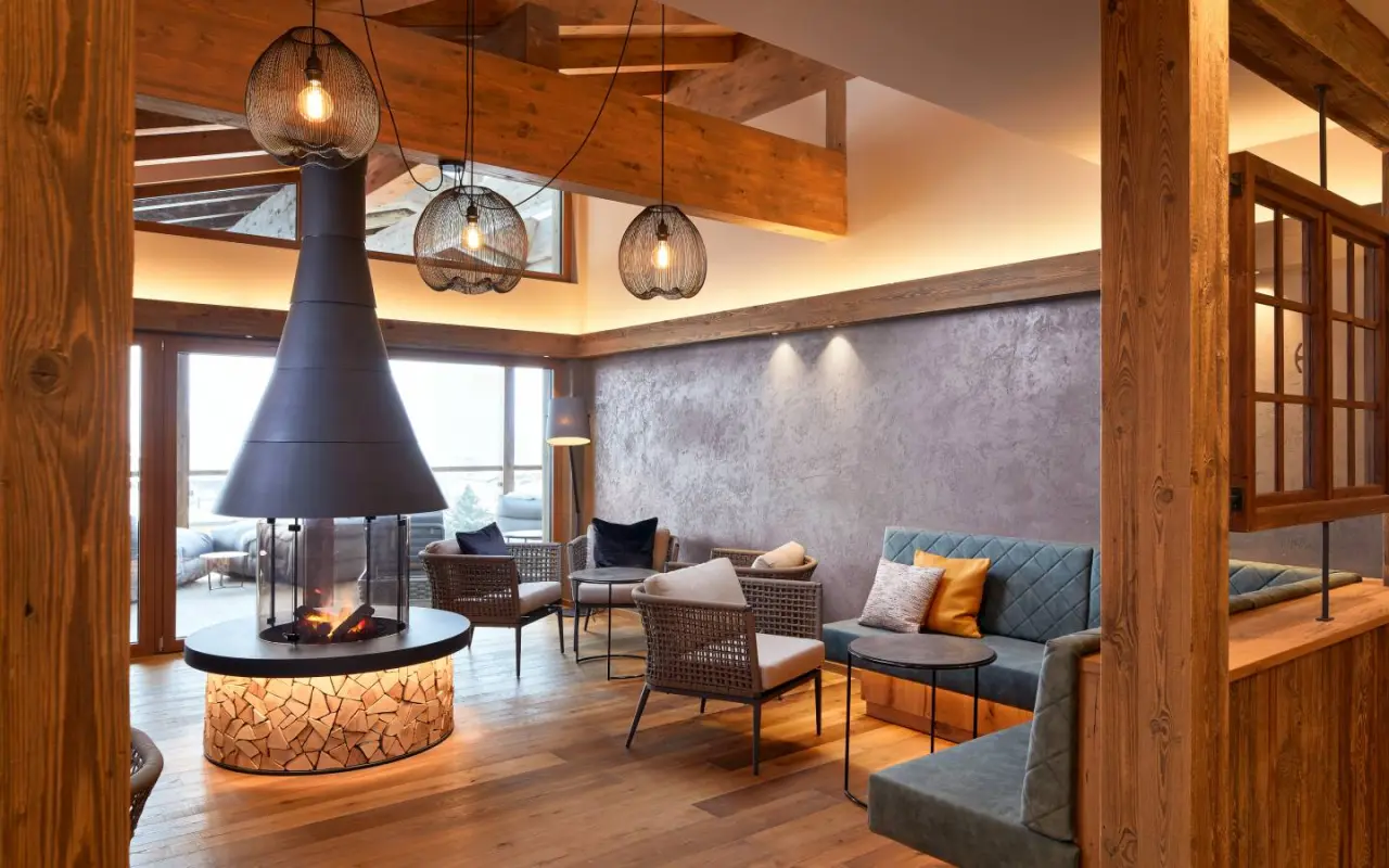 Einladende Hotellounge mit modernem Kamin und Holzakzenten im Hotel Wöscherhof, perfekt zum Entspannen.