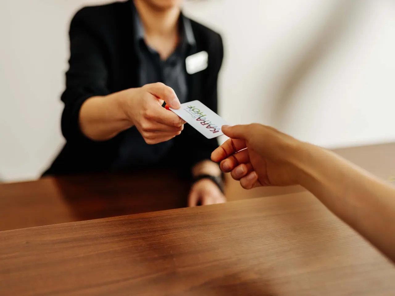 Check-in im Thermenhotel Karawankenhof: Gast erhält die Zimmerkarte von der Rezeptionsmitarbeiterin.