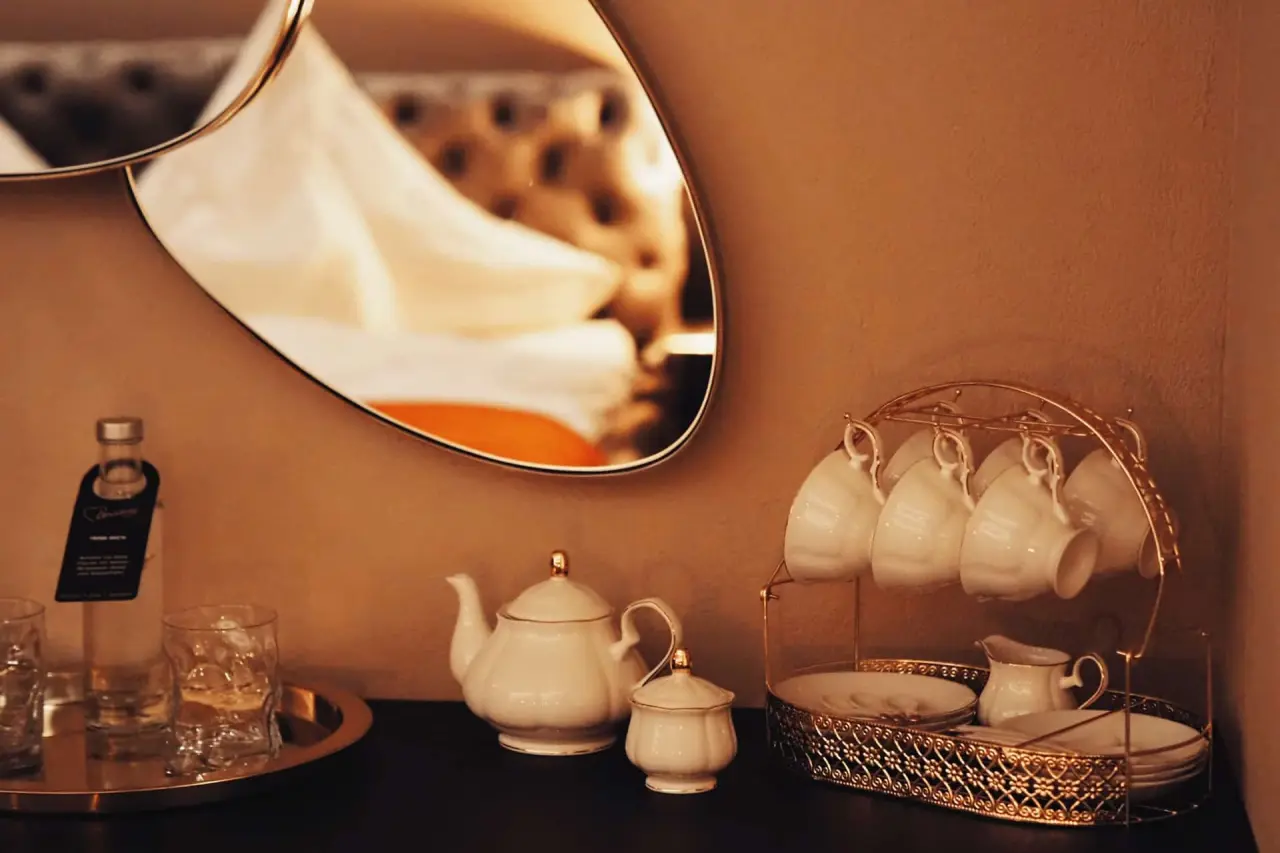 Elegantes Teeservice und Minibar-Getränke auf einem Sideboard im Zimmer des Hotel Universo.
