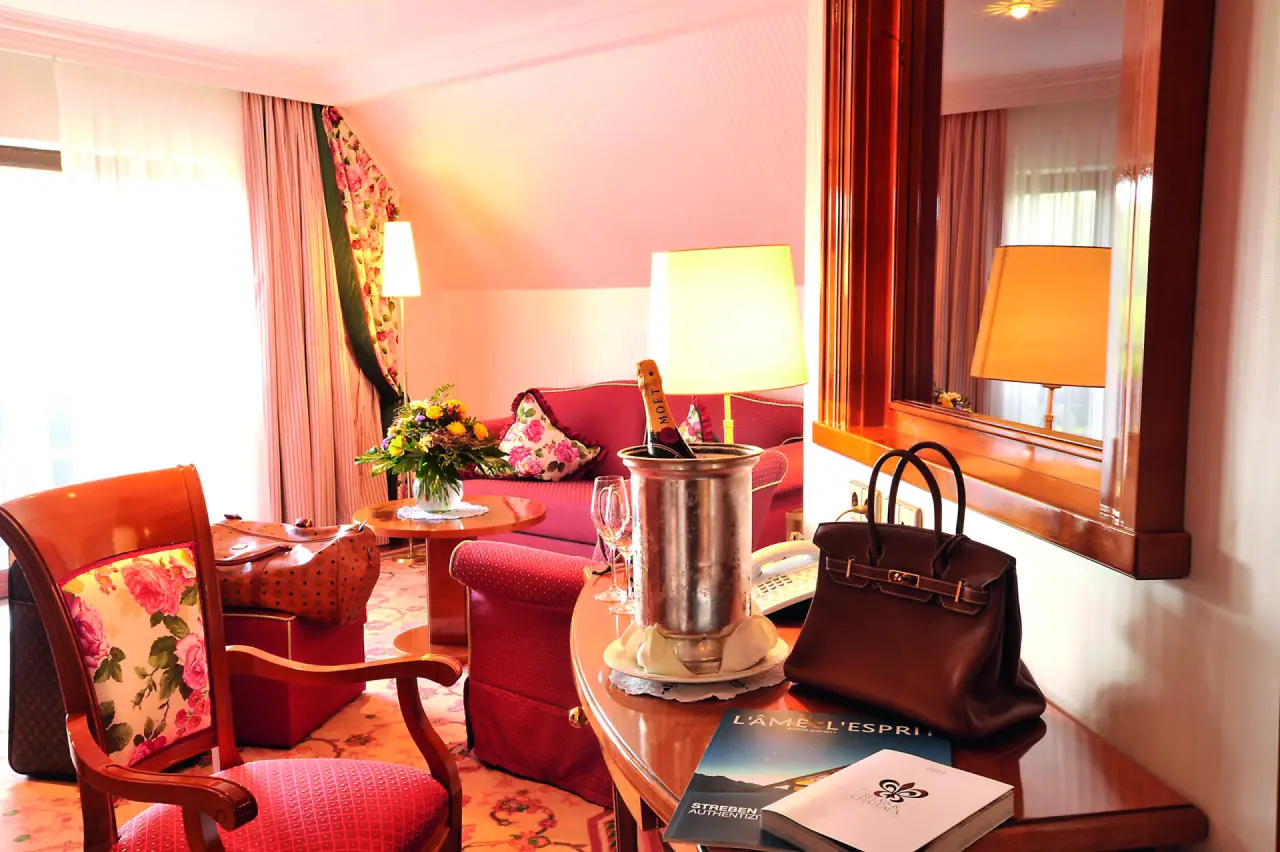 Komfortables Hotelzimmer im Haus Dollenberg mit Champagner, Blumen und eleganter Einrichtung. Perfekt für einen entspannten Aufenthalt.