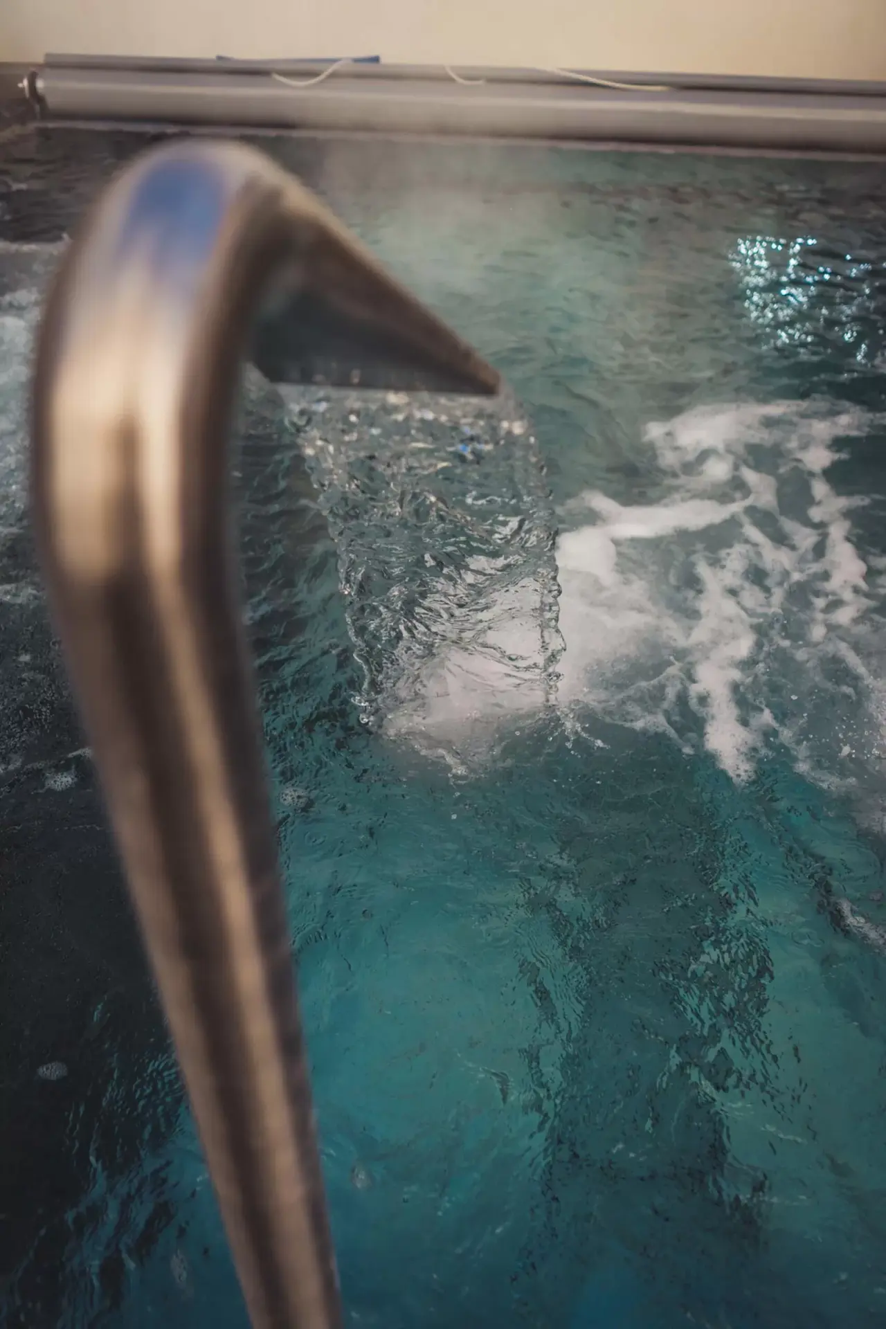 Detailaufnahme eines Wasserspeiers im Pool des Hotel LENZERHORN. Erfrischende Wasserstrahlen für Wellness.
