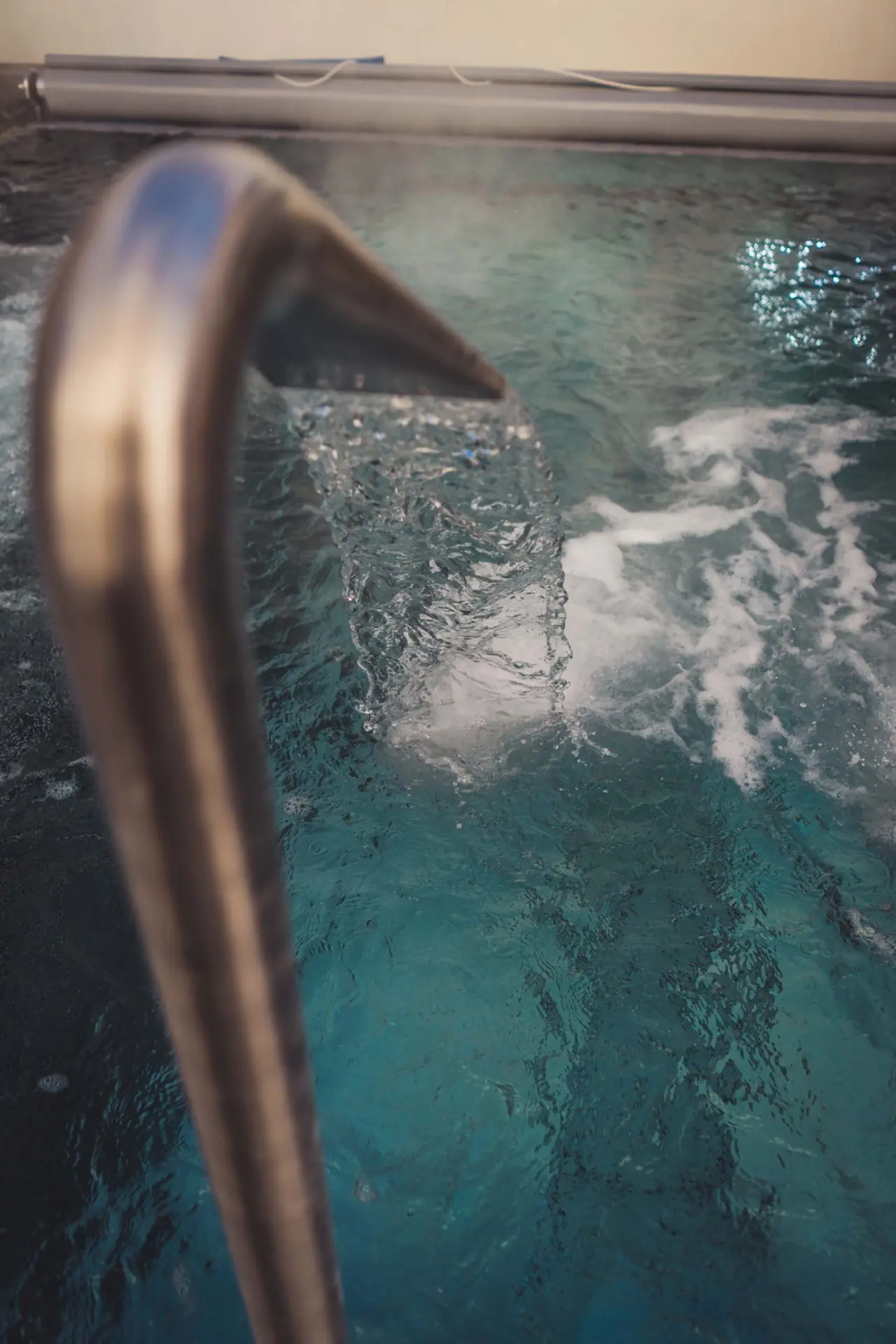 Detailaufnahme eines Wasserspeiers im Poolbereich des HOTEL LENZERHORN, der für Entspannung sorgt.
