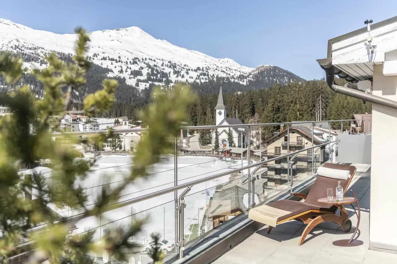 Balkon mit Liegestuhl, Blick auf verschneite Berge und Dorf im Winter, HOTEL LENZERHORN