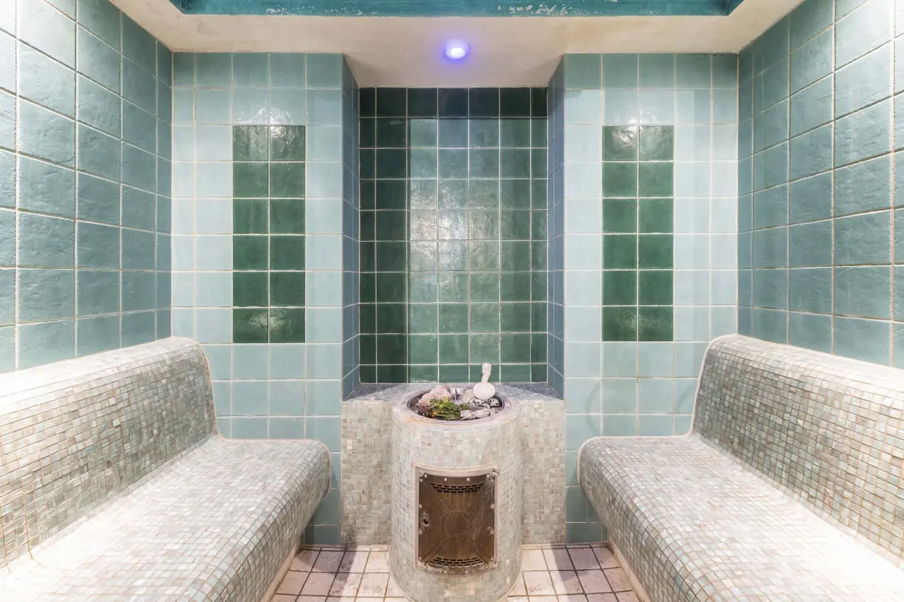 Dampfbad mit türkisen Mosaikfliesen und Aromabecken im Wellnessbereich des HOTEL LENZERHORN.