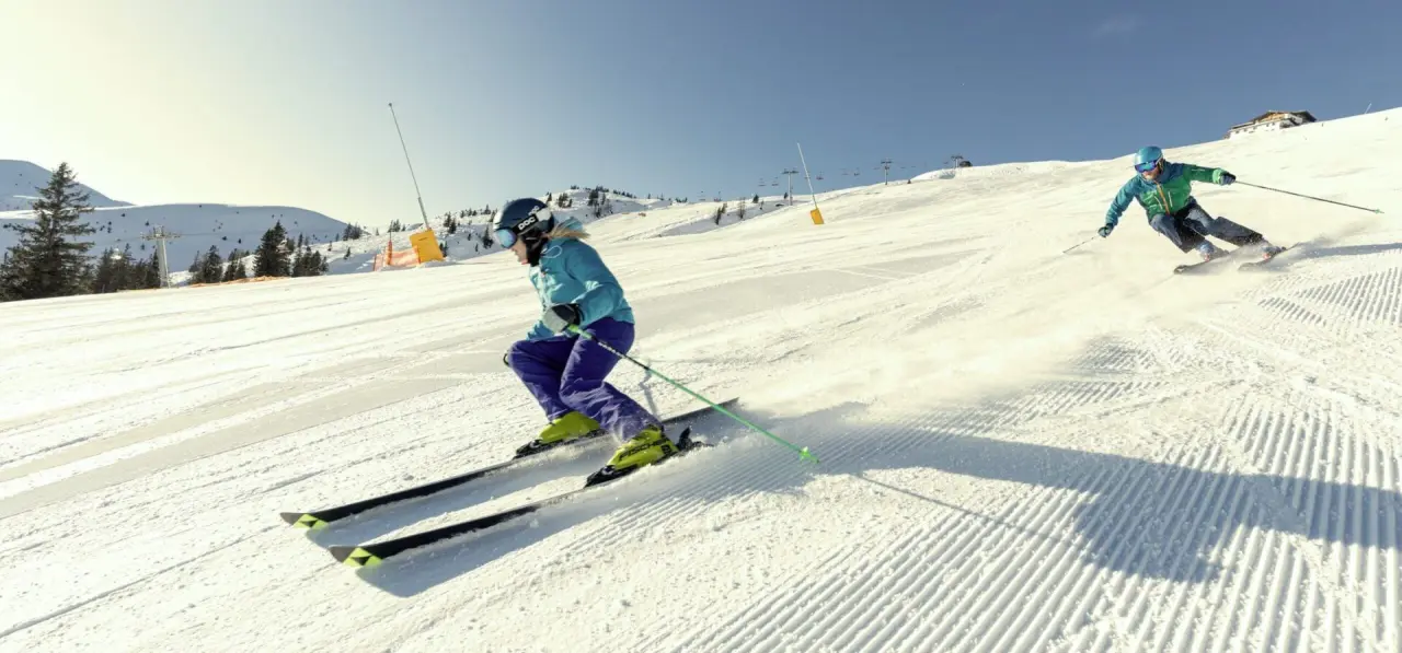 Skifahrer auf frisch präparierter Piste mit Bergpanorama nahe dem Aktiv- & Wellnesshotel Pirchnerhof.