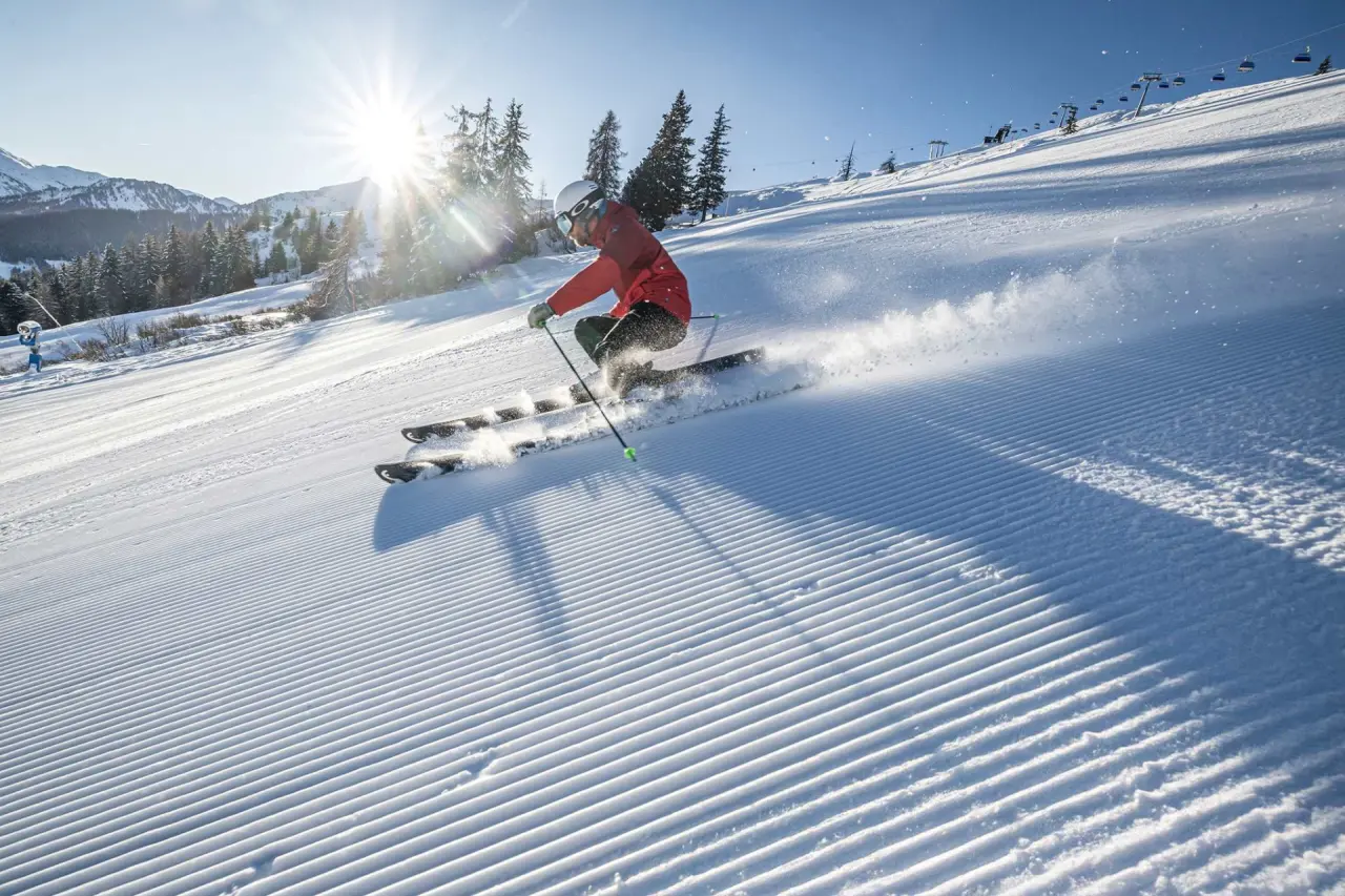 Skifahrer auf sonniger, frisch präparierter Piste mit Bergpanorama im Aktiv- & Wellnesshotel Pirchnerhof.